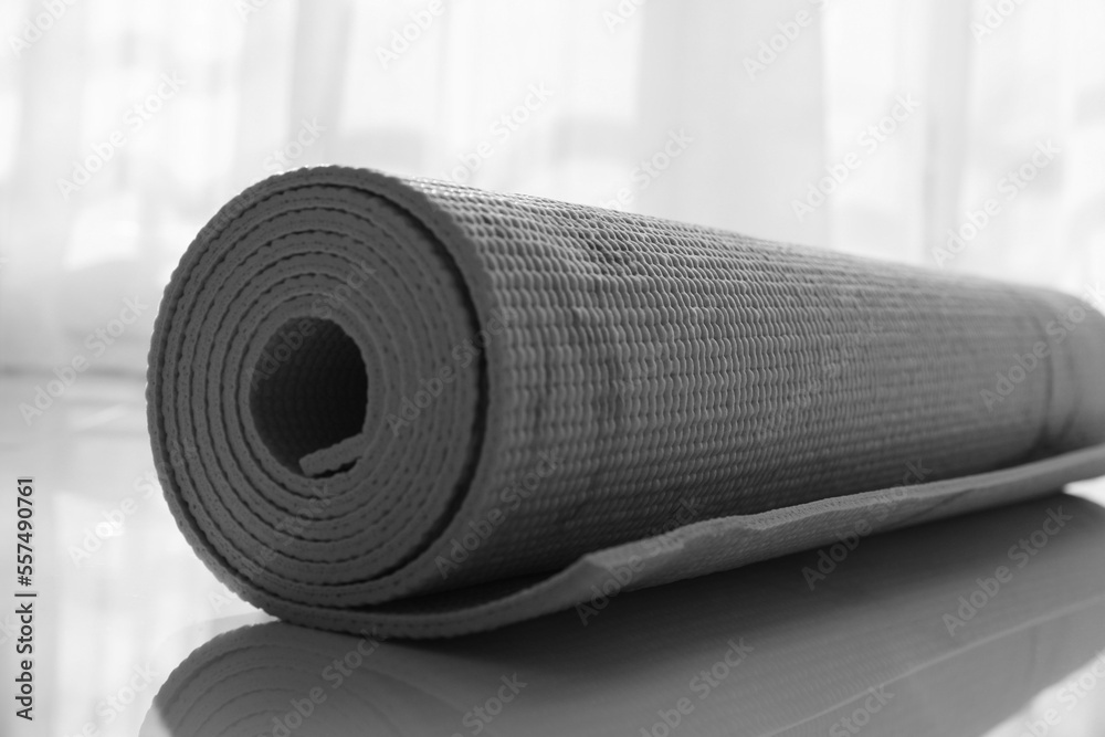 Rolled karemat or fitness mat on floor indoors, closeup Rolled karemat or fitness mat on floor indoors, closeup
