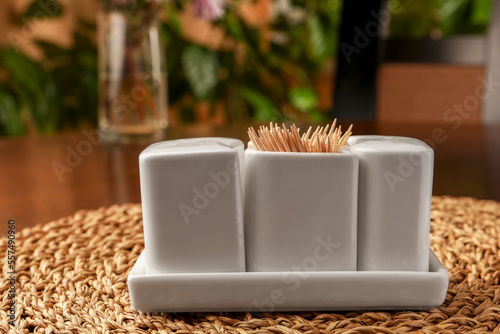 Holder with salt, pepper and toothpicks on wicker mat