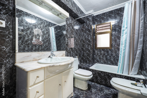 Bathroom with nameless style black tiles with which they have covered the floor and walls and that tires the eye