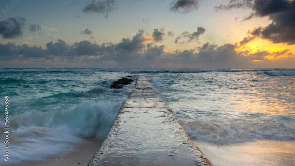 Barbados - a  perspective view of a stone pier with a colorful sunset