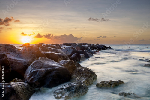 Tranquill sunset with large stones going into sea