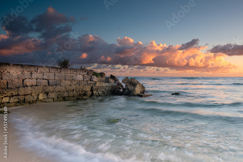 Sunset in Barbados - pink clouds and stone wall