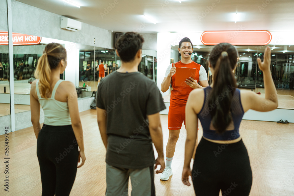 Fototapeta premium woman in sportswear asks by raising her hand during a briefing with an instructor before exercising