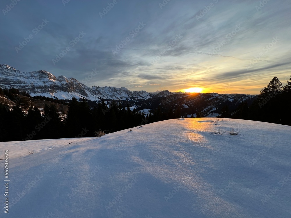 Magical sunset and shy sun behind winter clouds over the Obertoggenburg region and in the Swiss Prealps, Urnäsch (Urnaesch or Urnasch) - Canton of Appenzell Innerrhoden, Switzerland (Schweiz)