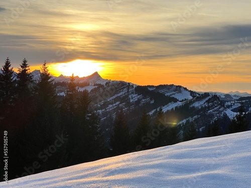 Magical sunset and shy sun behind winter clouds over the Obertoggenburg region and in the Swiss Prealps, Urnäsch (Urnaesch or Urnasch) - Canton of Appenzell Innerrhoden, Switzerland (Schweiz) photo