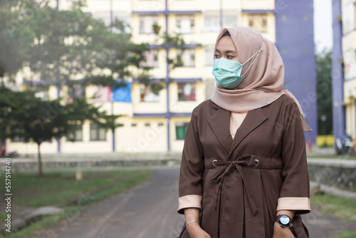 Woman in hijab wears medical mask standing to protect her from air pollution, transmissible infectious diseases and virus © wella
