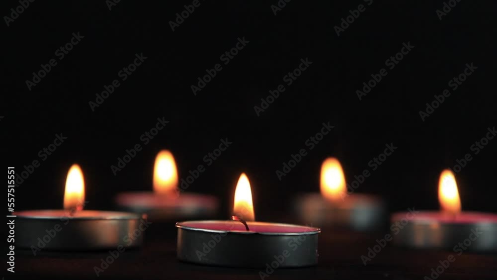 Candles of peace with dark and yellow flame on the dark. The candle burns with a soft yellow flame. Candlelight. Candles of peace with dark and yellow flame on the dark. The candle burns with a soft yellow flame. Candlelight.