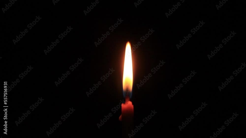 Candles of peace with dark and yellow flame on the dark. The candle burns with a soft yellow flame. Candlelight. Candles of peace with dark and yellow flame on the dark. The candle burns with a soft yellow flame. Candlelight.