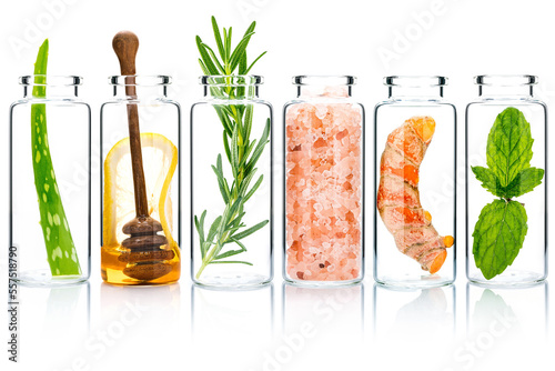 The glass bottle of homemade skin care and body scrubs with natural ingredients aloe vera ,himalayan salt ,peppermint ,rosemary ,turmeric and honey isolate on white background.