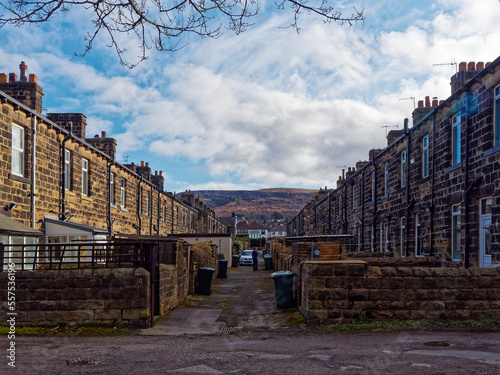 The Back Alley of the terraced houses in a street in Ilkley Town, with Ilkley Moor in the Background under a blue sky with scattered clouds photo