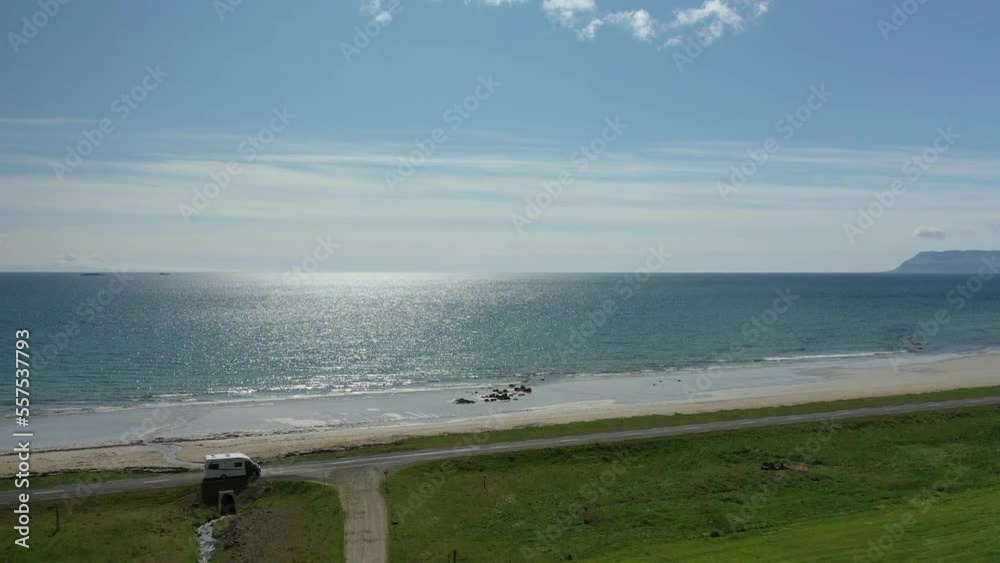 Coast of the Icelandic sea, crystal clear water, sunny weather, shot from a drone, car driving on the road, road near the sea Coast of the Icelandic sea, crystal clear water, sunny weather, shot from a drone, car driving on the road, road near the sea