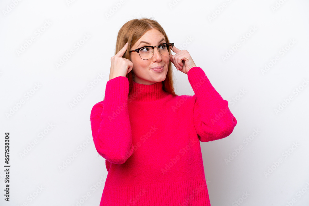 Young redhead woman isolated on white background having doubts and thinking Young redhead woman isolated on white background having doubts and thinking
