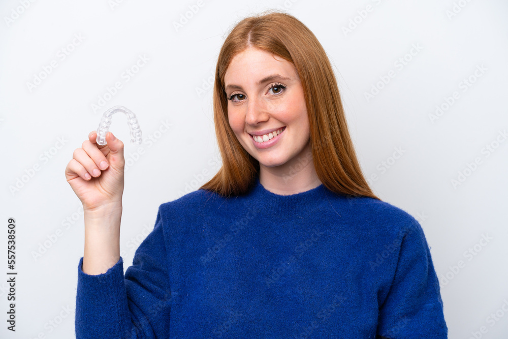 Young redhead woman holding invisible braces isolated on white background smiling a lot Young redhead woman holding invisible braces isolated on white background smiling a lot