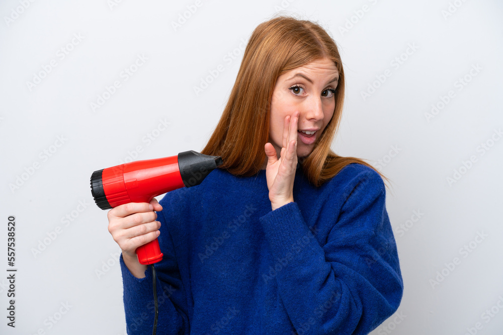 Young redhead woman holding a hairdryer isolated on white background whispering something Young redhead woman holding a hairdryer isolated on white background whispering something