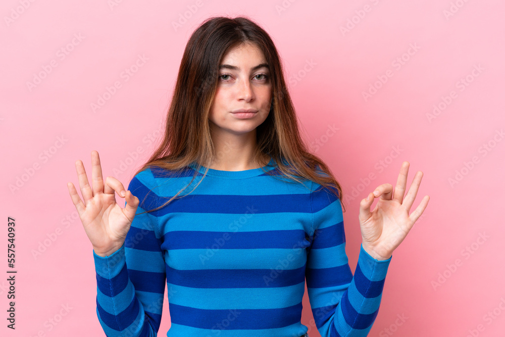 Young caucasian woman isolated on pink background in zen pose Young caucasian woman isolated on pink background in zen pose