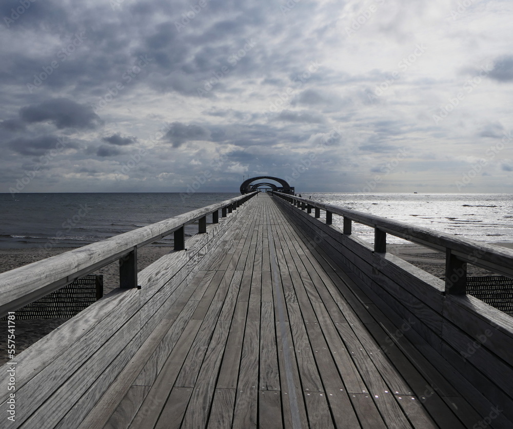 Wooden pier to the east sea in Kellenhusen. Holzsteg , Ostsee Wooden pier to the east sea in Kellenhusen. Holzsteg , Ostsee