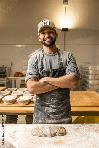 Bakers school, master baker kneading bread dough on table with flour, posing for portrait