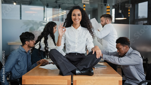 Φωτογραφία Happy calm smiling businesswoman female leader woman sitting on table in lotus p