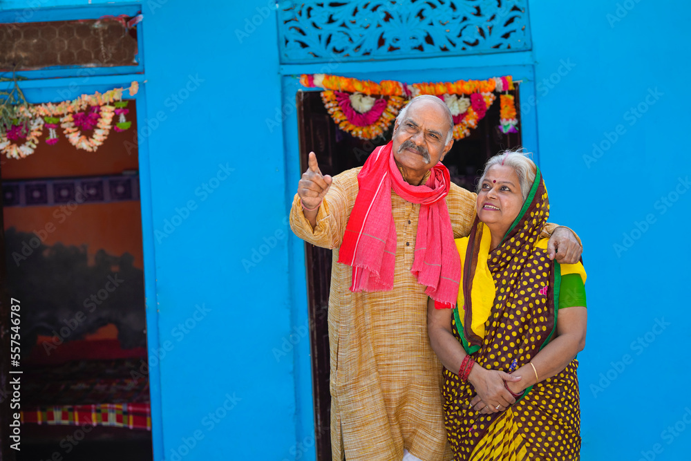 Old and senior indian farmer couple giving happy expression at home.