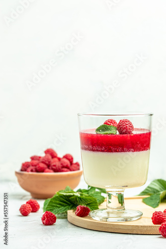 Berry dessert with cream sauce in small jars. Italian dessert. Raspberry Panna cotta with raspberry jelly on a light background. vertical image. top view. place for text