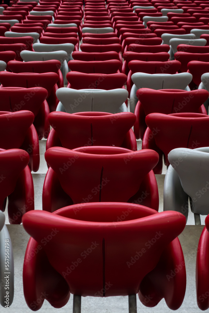Obraz premium Rows of empty white and red chairs in a football stadium. Anticipation of an upcoming sporting or cultural event.