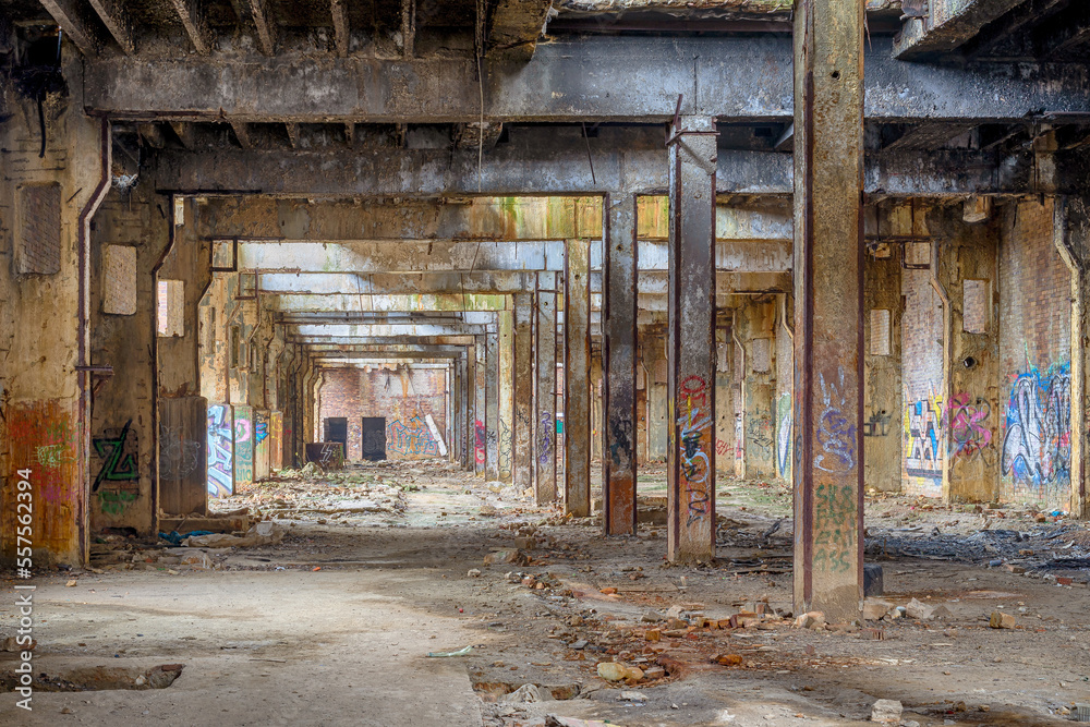 Abandoned factory ruins. Damaged  industrial structures with rubbish and graffiti walls