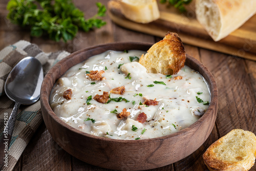 New England clam chowder with bacon, parsley and toasted bread photo