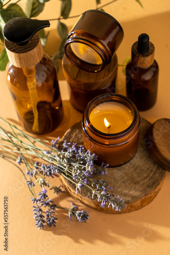 Soy candles in a glass jar. Aromatherapy. Burning candle and lavender. Wooden lid for jars. Beige background. Comfort and relaxation. Handmade. Home decor.