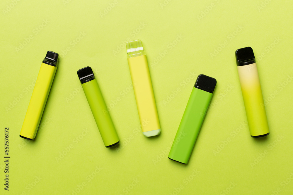 Disposable electronic cigarettes on color background, top view Disposable electronic cigarettes on color background, top view