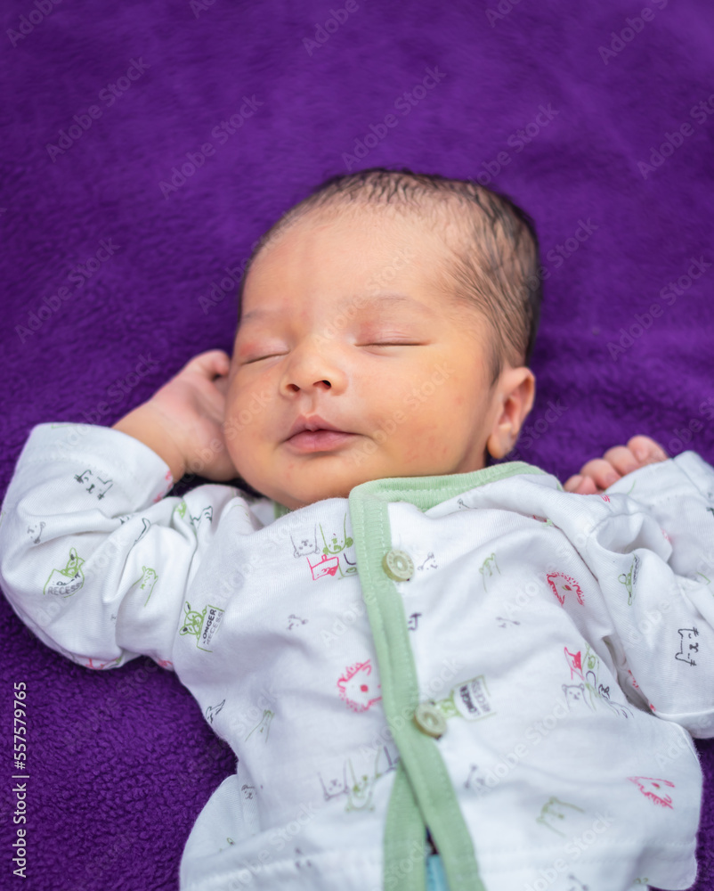 newborn baby isolated sleeping in white cloth with purple background from different angle newborn baby isolated sleeping in white cloth with purple background from different angle