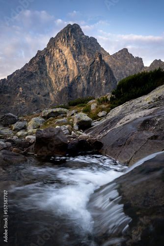 Peaks of the High Tatras with a waterfall in the foreground.