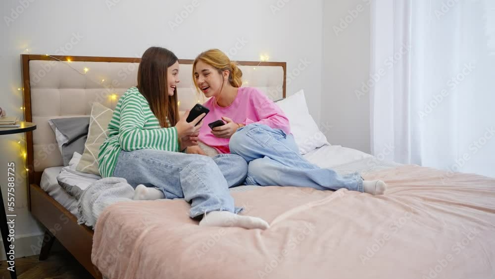 Cute 15-17 years teenage girls, using smartphone, checking social media content in the home interior Cute 15-17 years teenage girls, using smartphone, checking social media content in the home interior