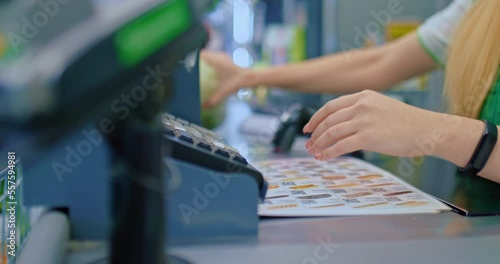 woman works at counter in department store, scanning goods of clients, closeup view, 4K, Prores
