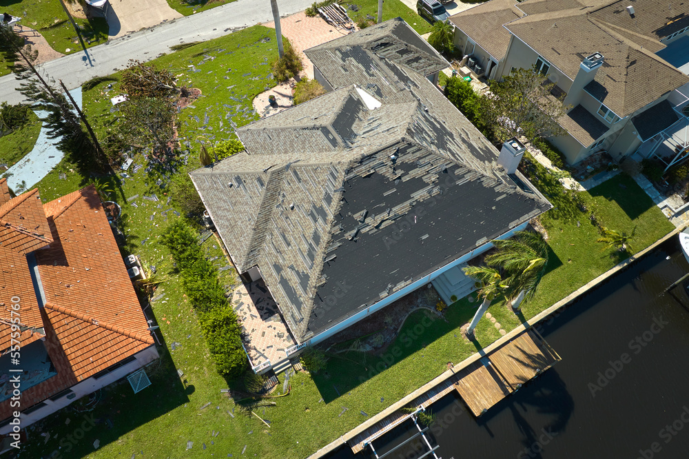Fototapeta premium Hurricane Ian destroyed house roof in Florida residential area. Natural disaster and its consequences