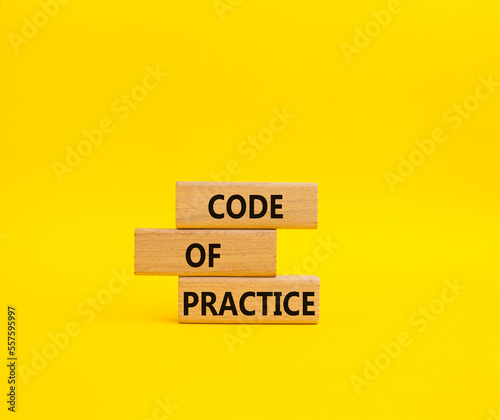 Code of Practice symbol. Concept word Code of Practice on wooden blocks. Beautiful yellow background. Business and Code of Practice concept. Copy space