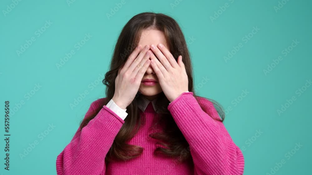 Close-up of young female looking shocked and scared. Portrait of a teenage girl closing her eyes with hands. High quality 4k footage Close-up of young female looking shocked and scared. Portrait of a teenage girl closing her eyes with hands. High quality 4k footage