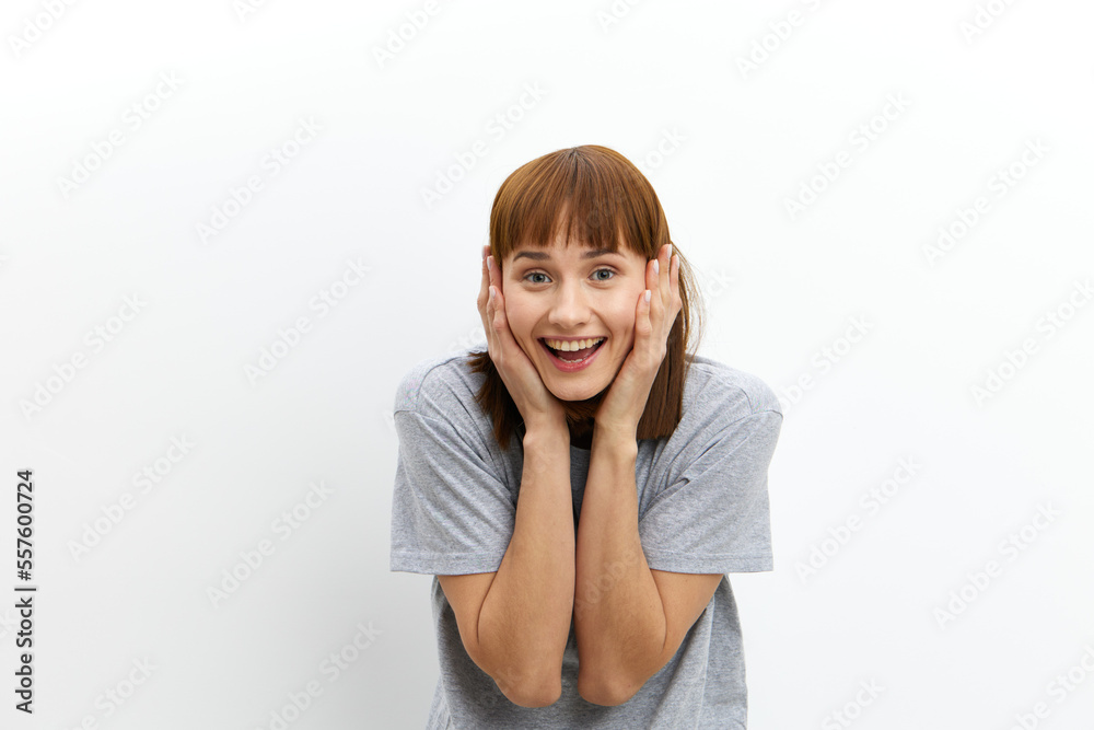 a happy, joyful, cheerful woman smiles broadly looking at the camera and holds her hands in an enthusiastic gesture near her face. Horizontal photo with an empty space for inserting an advertising a happy, joyful, cheerful woman smiles broadly looking at the camera and holds her hands in an enthusiastic gesture near her face. Horizontal photo with an empty space for inserting an advertising