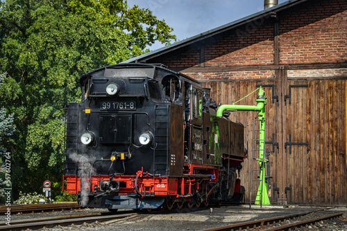a steam locomotive replenishes water in the depot