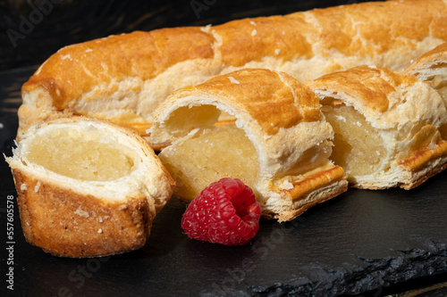 Fresh baked Dutch filled spicy cookies from puff pastry with almonds in autumn colors on dark stone photo