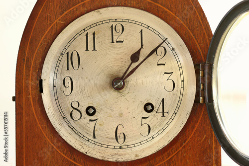Clock face with glass door open to allow clock to be wound. This is an eight day movement.