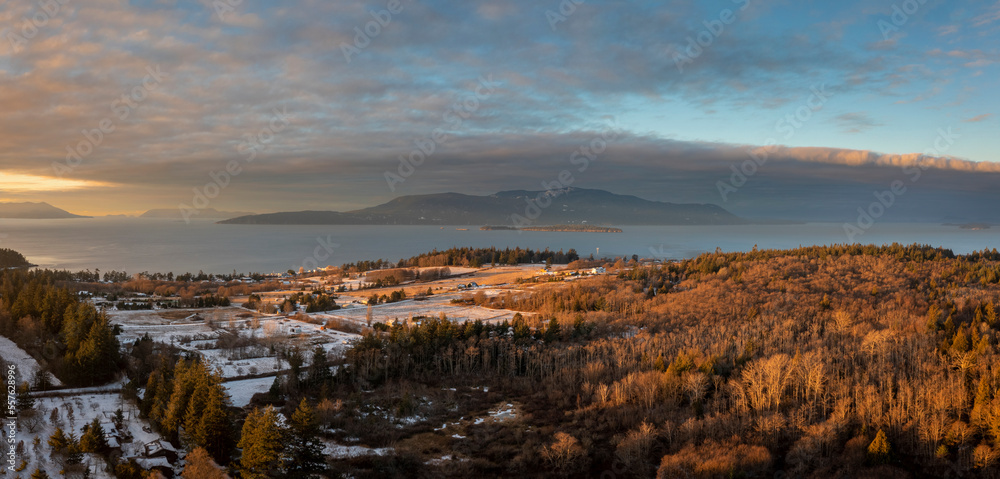 Aerial Sunrise View of a Snowy Lummi Island with Orcas Island in the Background. Panoramic look at a winter scene in the San Juan Islands in Washington state.