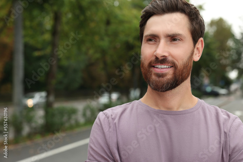 Portrait of handsome bearded man on street, space for text