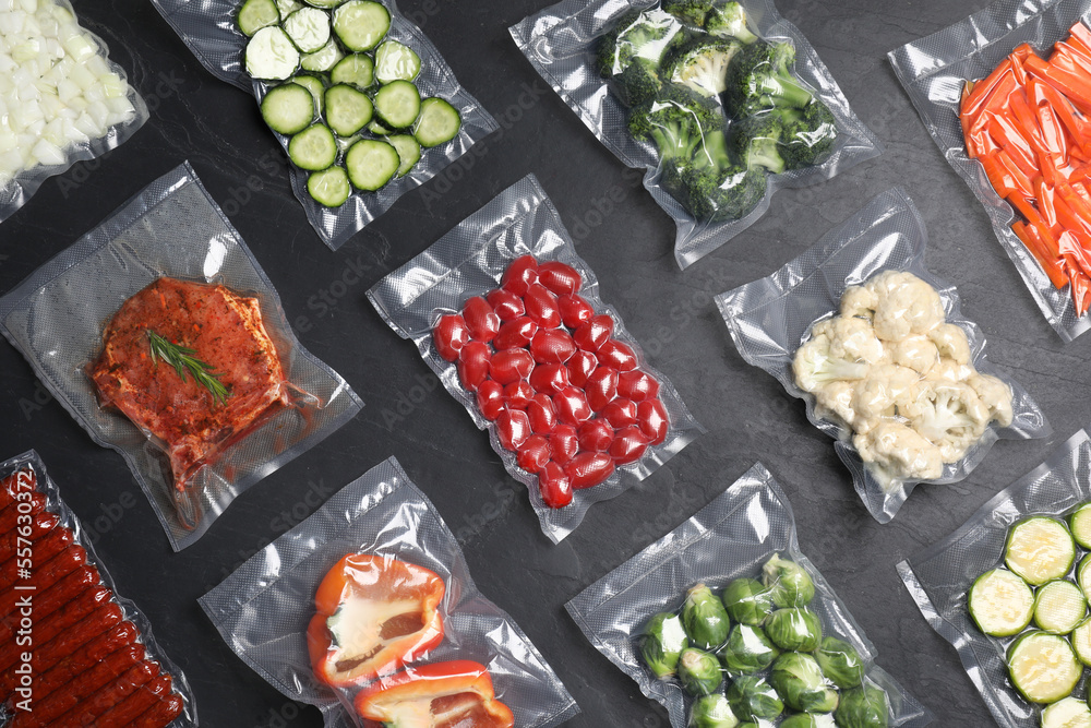 Flat lay composition of different food in vacuum packings on dark grey table - obrazy, fototapety, plakaty 