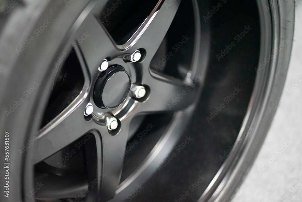 Closeup of beautiful big alloy wheels of a black gray expensive supercar