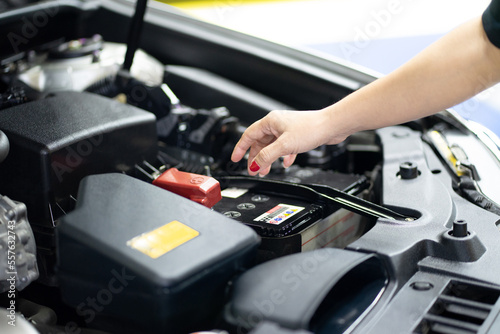Woman fixing parts while opening car hood repairing engine and inspecting engine