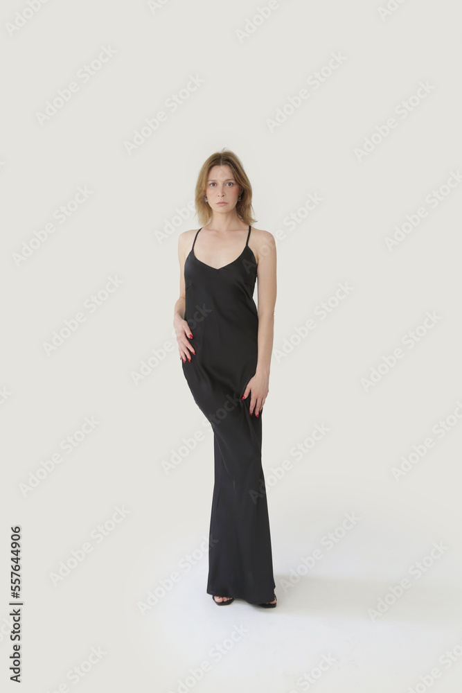 Female fashion model in long black silk camisole dress, studio shot. Female fashion model in long black silk camisole dress, studio shot.