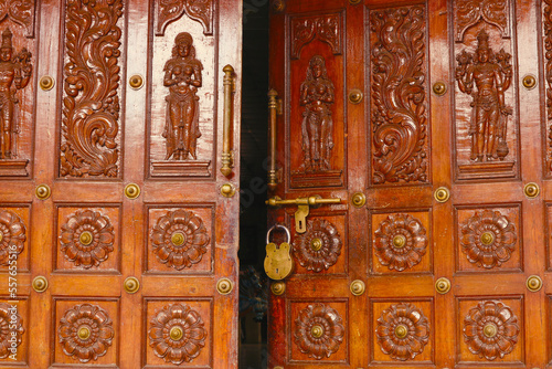 The door to the Hindu temple with a large lock and a deadbolt is slightly ajar.
