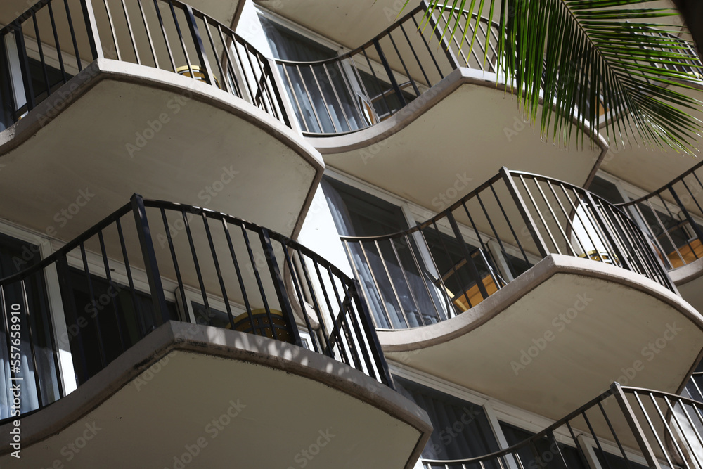 Fototapeta premium Small balconies with palm frond on tropical apartments, hotel or resort