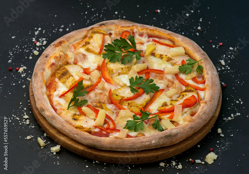 Traditional Italian pizza with ham, cheese and tomatoes on a dark background