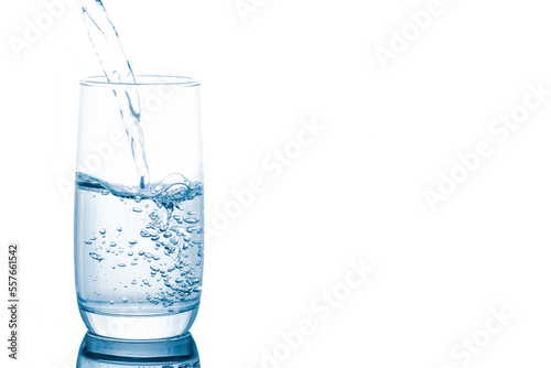 Spring water pouring into glass isolated on white background.